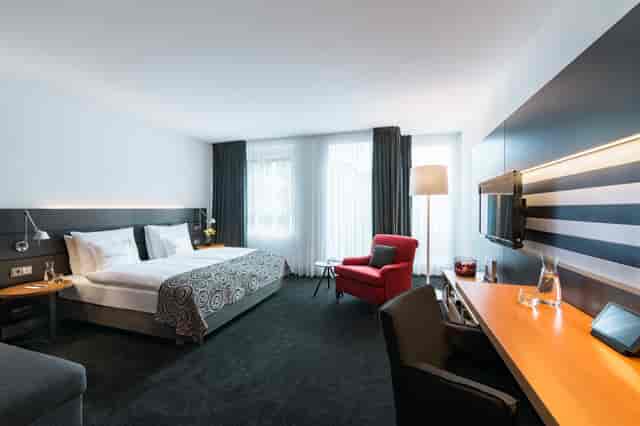 Modern hotel room at THE MADISON Hamburg, ideal for business travelers and events.