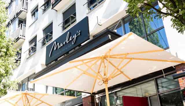 Outdoor dining area at Marley's, modern venue for casual meetings in Hamburg.