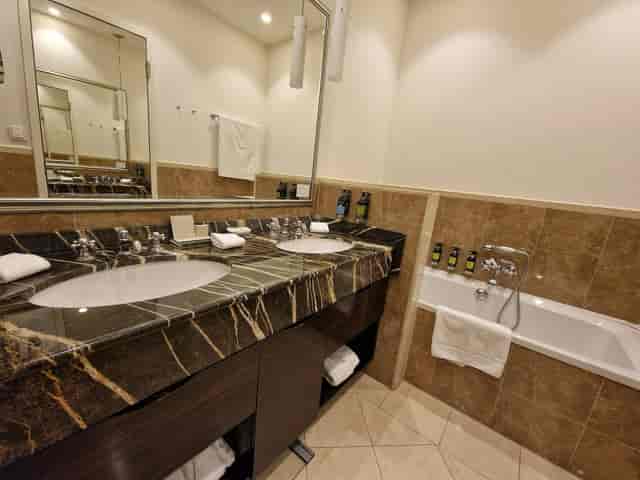 Elegant hotel bathroom with marble dual sinks at Atlantic Hamburg for business events.