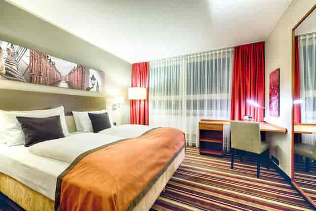 Hotel room in Leonardo Hotel Hamburg City Nord, featuring a spacious work desk for events.
