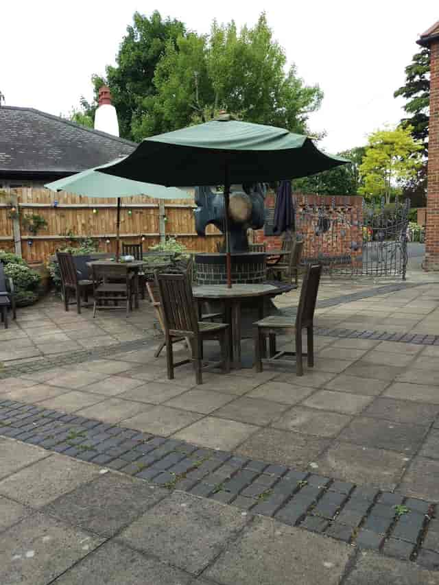 Outdoor event space at Riverhouse Barn with cozy wooden seating under an umbrella.