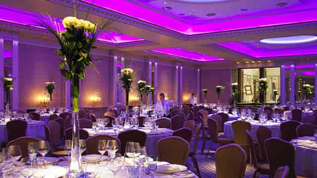 Elegant private dining room with round tables and floral centerpieces for formal events.