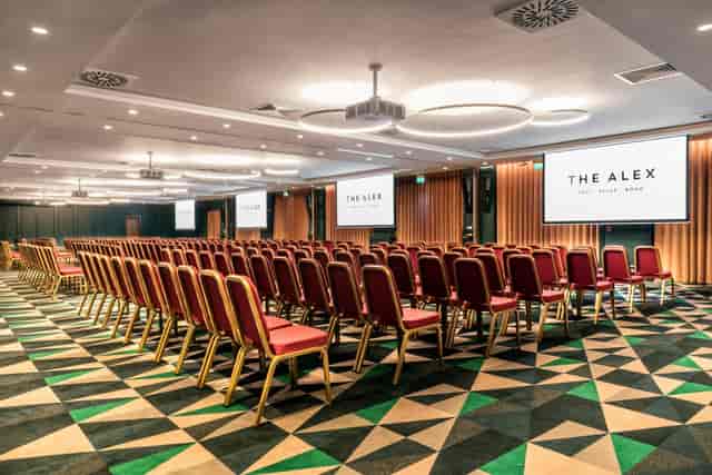 The Odyssey meeting space in The Alex Hotel with red chairs for conferences and seminars.