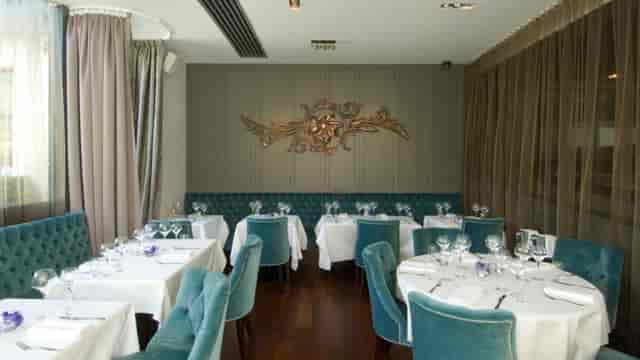 Elegant restaurant with teal chairs, perfect for corporate dinners and intimate events.
