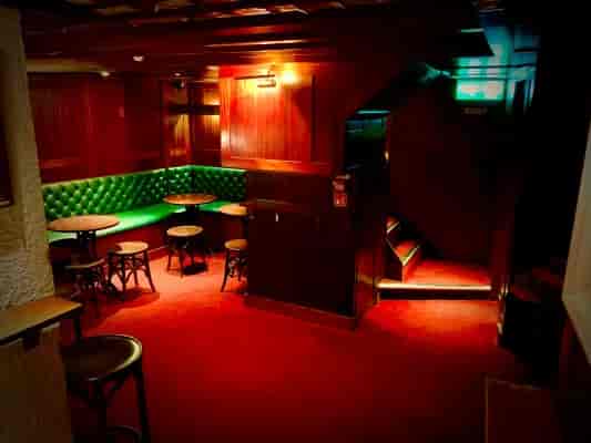 Cozy bar with rich wood, ideal for private meetings and small gatherings.