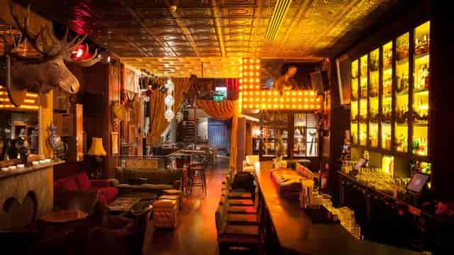 Eclectic bar with warm lighting in The Dawson Lounge, ideal for networking events.