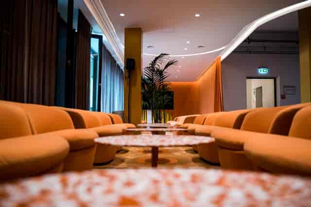 Modern event space with orange seating, perfect for networking and gatherings.
