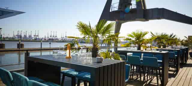 Stylish outdoor event space with modern furniture and waterfront view for cocktail receptions.