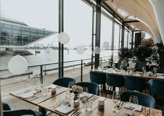 Elegant restaurant dining space with waterfront view, perfect for corporate events and gatherings.