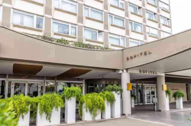 Modern Sofitel Lyon Bellecour entrance, elegant greenery, ideal for corporate events.
