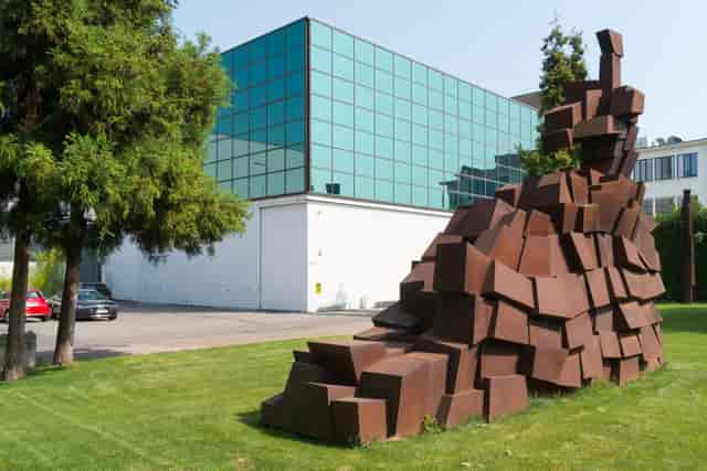 Modern glass venue with sculpture, outdoor event, corporate reception