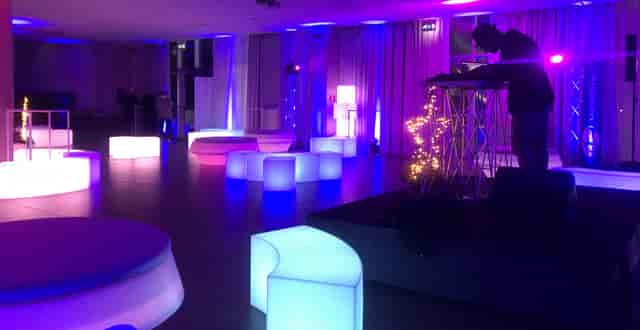 Modern event space, blue/purple lighting, DJ, networking event