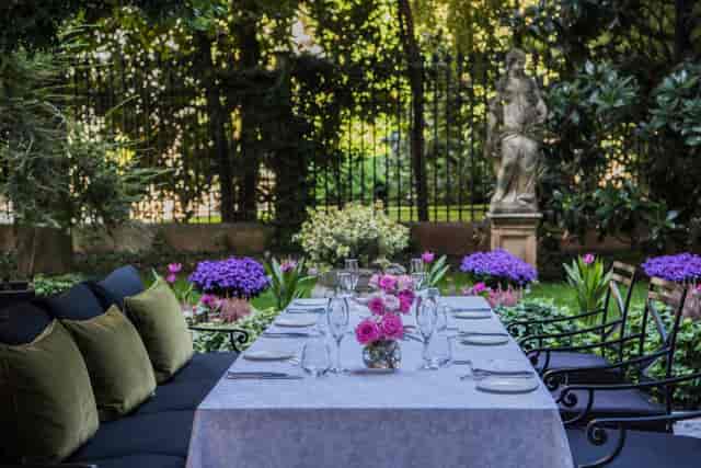 Elegant outdoor dining at Palazzo Parigi's lush garden, perfect for upscale events.