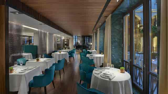 Elegant function room with teal chairs in Mandarin Oriental, Milan for upscale events.