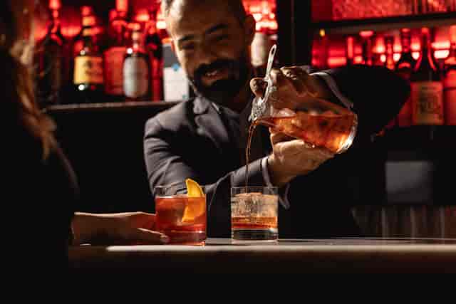 Bartender crafting cocktails at The Negroni Bar, perfect for networking events and celebrations.