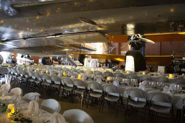 Aviation hangar banquet, museum gala, aircraft backdrop.