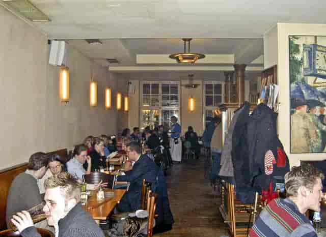 Cozy cafe event with bar, warm lighting, networking, reception.