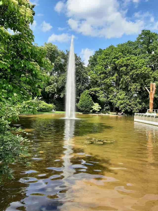 Upscale outdoor garden reception at Kongress am Park Augsburg with a striking water feature.
