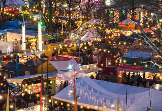 Pop-up market at Vereinsheim Schwabing with vendor stalls and string lighting for outdoor events.
