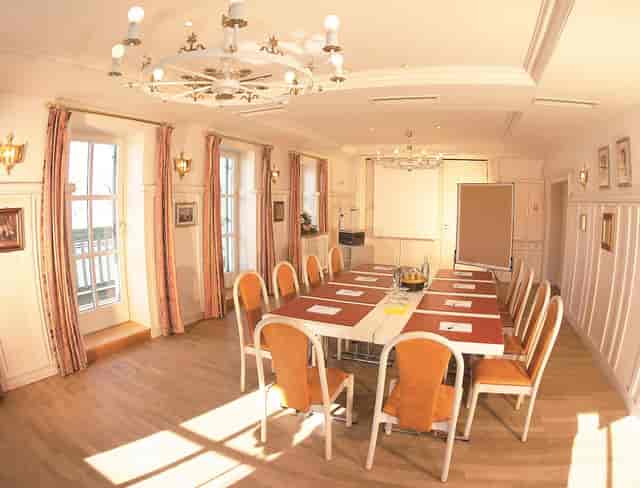 Boardroom setup in bright, elegant dining room for executive meetings and strategy sessions.