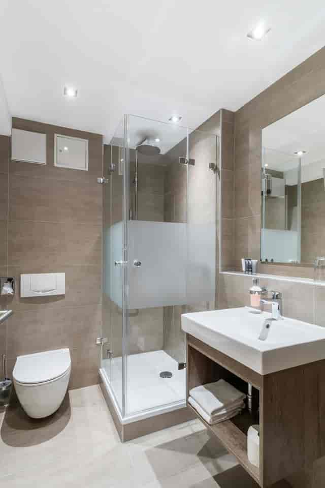 Modern hotel bathroom with walk-in shower for event attendee lodging and conference room blocks.
