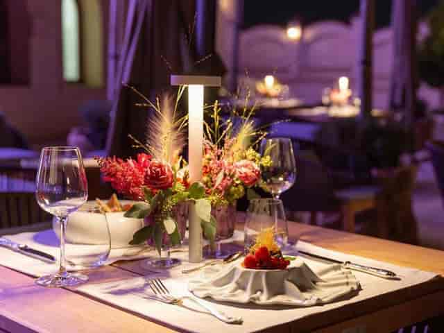 Al fresco dining at Suter Palace event hall with modern lighting and floral wedding decor.
