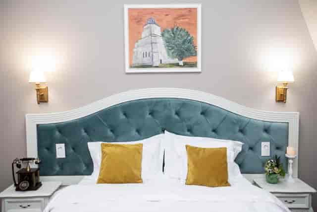 Boutique hotel room with teal tufted headboard for luxury corporate events and VIP retreats.