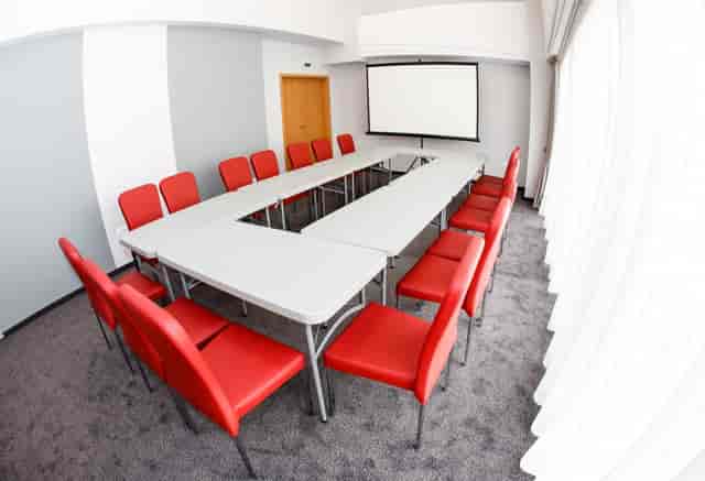 U-shape conference setup at Unirea Hotel with red chairs for corporate events and meetings.
