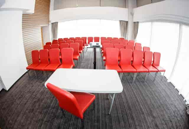 Theater-style seating at Orion Unirea Hotel, red chairs, professional event venue, conference space.