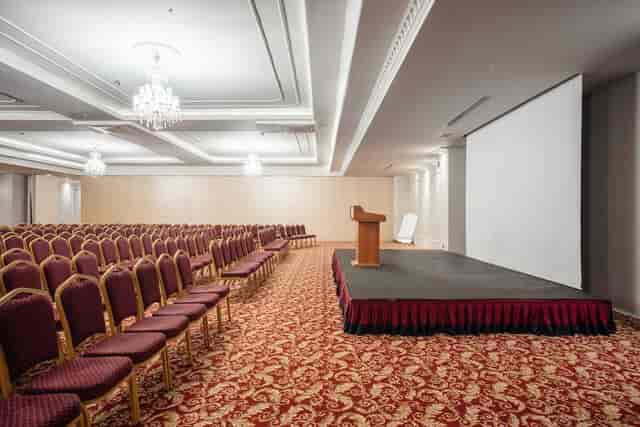 Verdi Meeting Room theater-style setup with stage and screen for corporate seminars and keynotes.
