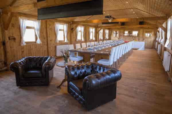 Rustic timber-framed meeting room and lounge area for corporate events and professional retreats.