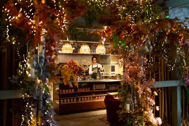 Floral bar installation with fairy lights for experiential event and wedding decor.