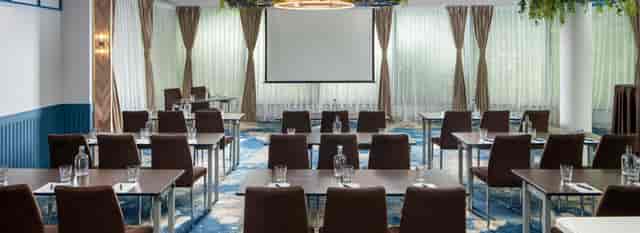Classroom-style event hall at Hotel Epoque with natural light for conferences and business meetings.