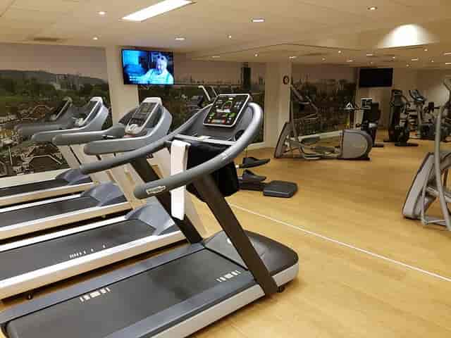 NH Amsterdam Zuid hotel fitness center with modern equipment for wellness and group events.