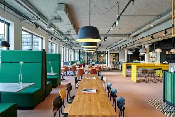 Modern Aristo Amsterdam breakout space with booths and tables for corporate networking workshops.