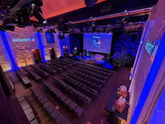 Corporate stage at TOBACCO Theater with tech-focused lighting for AI event keynote.