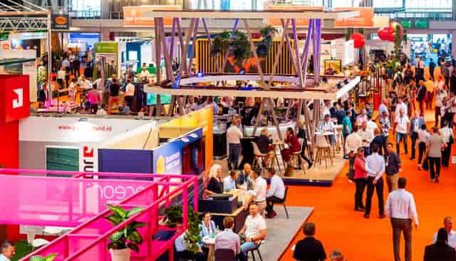 High-energy GreenTech trade show booth with vertical signage for attendee engagement.