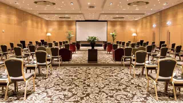 Classroom-style banquet hall with stage for corporate events and executive training.