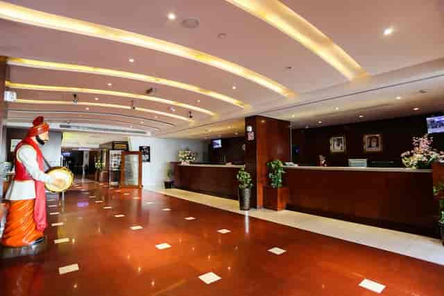 Spacious Ramee Royal Hotel lobby with long reception desk for corporate events and conferences.