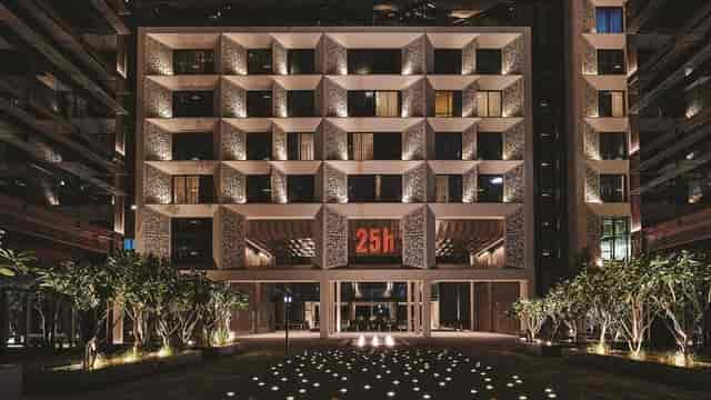 Ernst 25hours Hotel One Central facade with atmospheric lighting for corporate retreats.