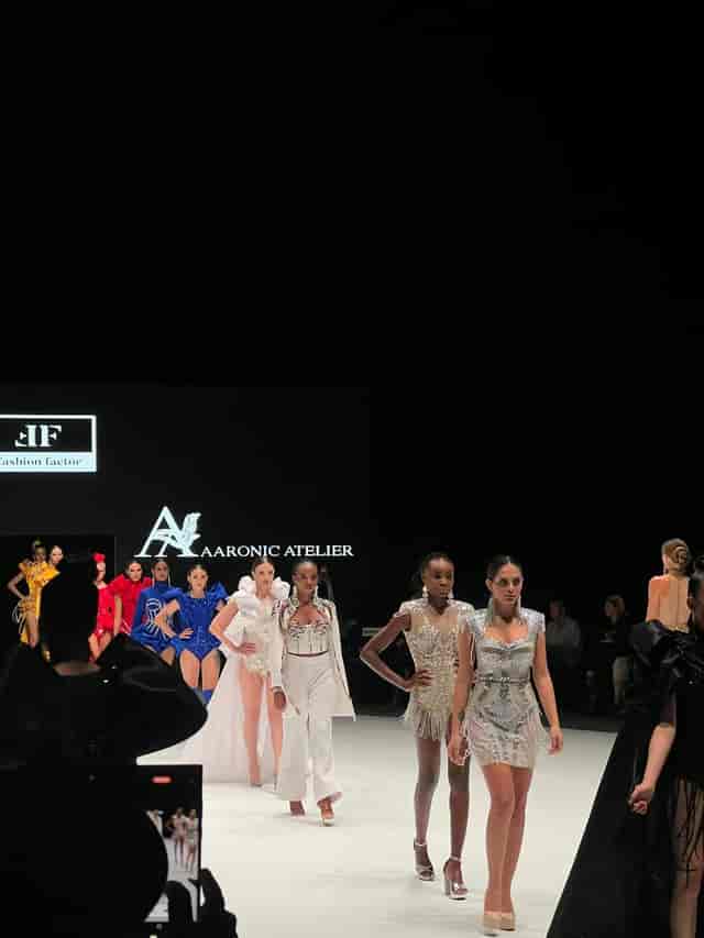 Main Auditorium runway show at The Agenda with branded backdrop and professional stage lighting.