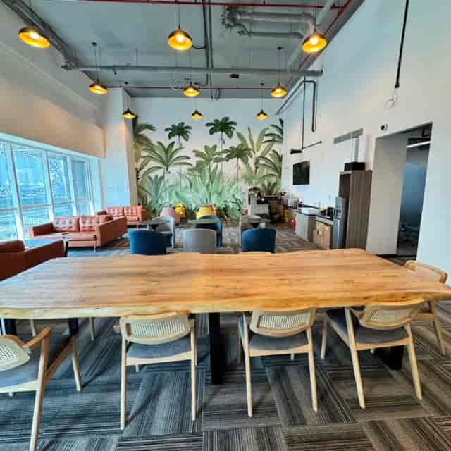 Czar Workspace coworking breakout area with communal table and mural for creative networking events.