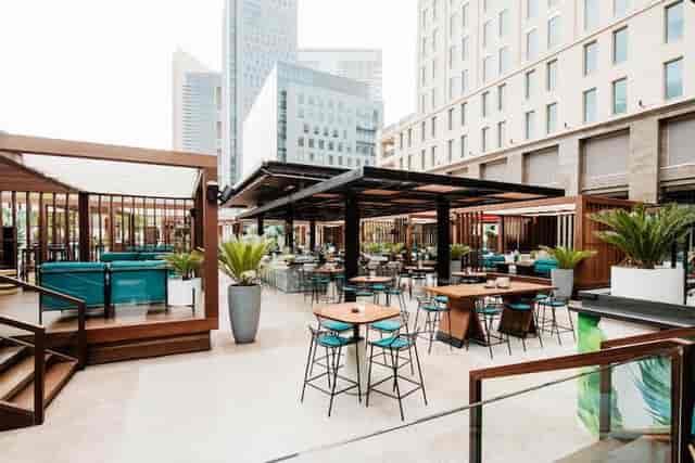High-end outdoor networking space with shade structures for cocktail receptions and events.