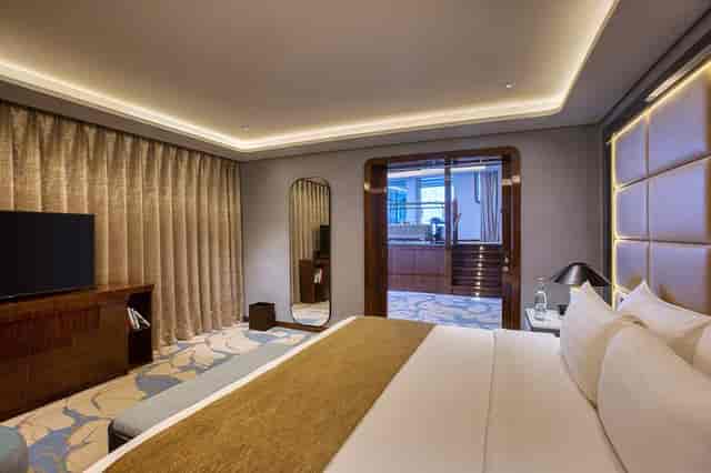 Luxury Legacy Room suite on QE2 with ambient lighting for VIP executive events and conferences.