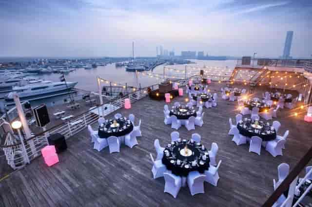 Corporate reception on Queen Elizabeth 2 deck with elegant black-and-white banquet seating.
