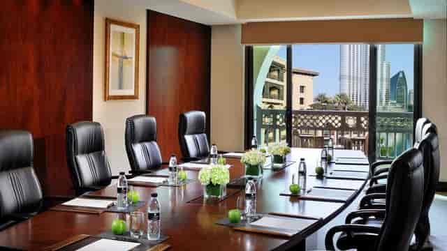 Executive boardroom with mahogany table and skyline view for VIP corporate meetings.