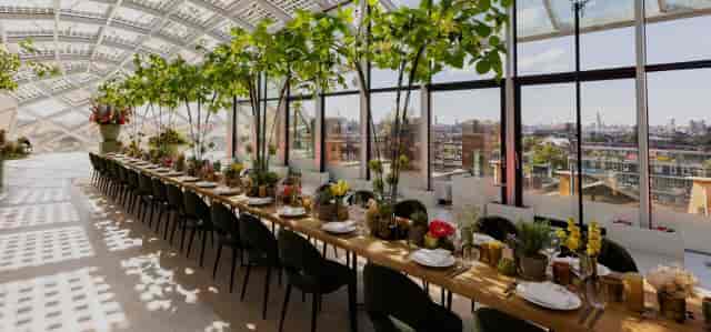 Elegant event space in Amsterdam with greenery, perfect for networking or dining.