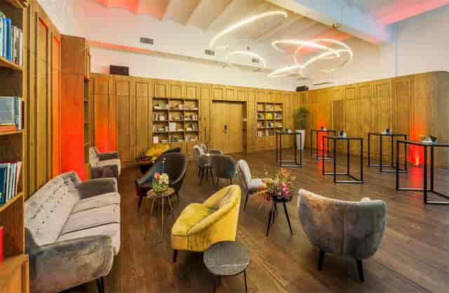 Modern event space in Hotel Arena Amsterdam with warm wood and plush seating.