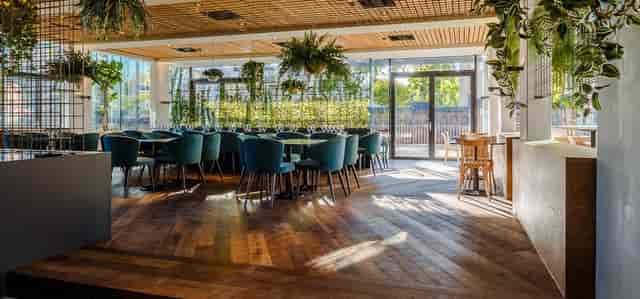 Park Café in Hotel Arena Amsterdam: modern event space with lush greenery, ideal for gatherings.