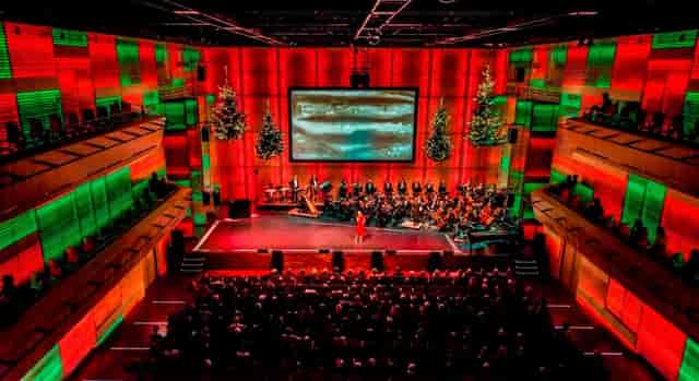 Orchestral performance in a decorated auditorium for festive cultural events.